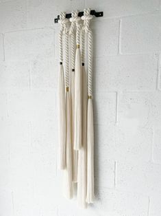 three white tassels hanging on the wall next to a black and white clock