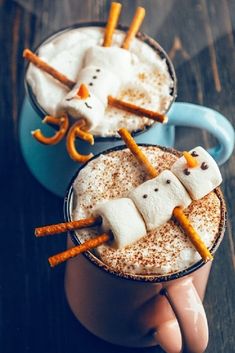 two cups filled with hot chocolate and marshmallows in the shape of snowmen