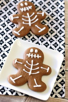 two decorated ginger cookies on a white plate