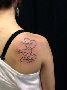 the back of a woman's shoulder with two hearts on it and an inscription