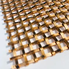 a piece of gold colored metal mesh on a white surface