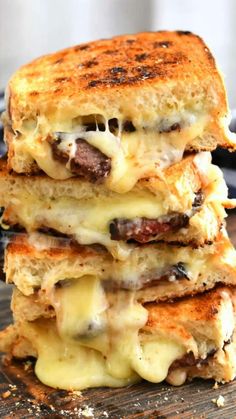 three grilled cheese sandwiches stacked on top of each other with melted cheese and meat