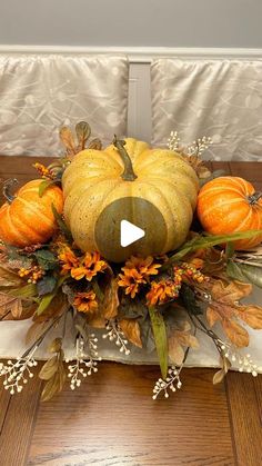 a wooden table topped with pumpkins and flowers