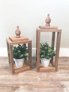 two wooden lanterns with plants in them on the floor