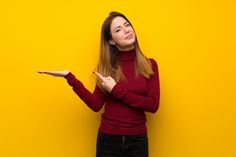 a woman in a red sweater is holding her hand out to the side and looking up