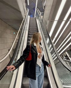 a woman standing on an escalator with her arms outstretched