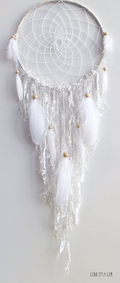 a white dream catcher hanging on the wall