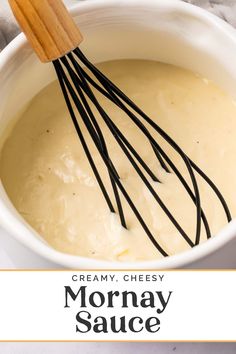 creamy cheese sauce in a white bowl with black whisks on top and the words, creamy cheesy