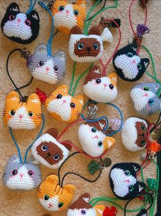 many small crocheted cats are hanging on the wall with their eyes open and ears closed