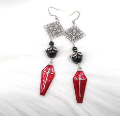 This listing features my handmade earrings in red, black and silver.  They start with silver tone red enamel coffin charms.  They are shimmery red and silver with a cross on the front and silver on the back - please see all photos.  Above I added high quality crystal cored mystic black colored pearls and lots of pretty antique silver plated brass filigree elements.  The earrings are long and measure 3 1/4 inches including the stainless steel non allergenic ear wires.  Width is 3/4 inch across th Red Coffin, Colored Pearls, Weirdcore Aesthetic, Brass Filigree, Goth Jewelry, Black Jewelry, Cross Earrings, Pearl Color, Earrings Silver