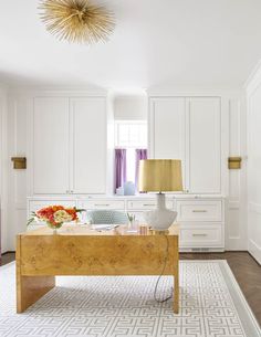 a white and wood desk in the middle of a living room with an area rug