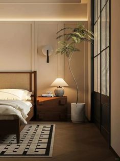 a large bed sitting next to a tall plant in a bedroom under a ceiling light