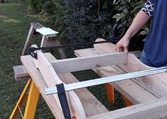 a man is working on some wood in the yard