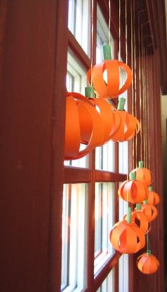 some orange paper lanterns hanging from a window