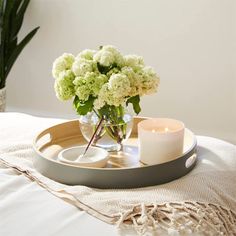 a tray with some flowers and candles on it