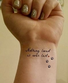 a woman's wrist with a tattoo saying nothing loved is ever lost