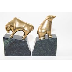 two brass bull sculptures on marble bases