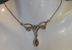 A fine solid silver and citrine set celtic styled necklace . the pendant part of the necklace is in form of a celtic  knot with a marquise cut citrine gemstone dangling from centre. the pendant part measures 3.8cm wide x 3.5cm drop. has a silver link chain attached to either side, overall length 18 inches. looks very stylish when worn. stamped 925 for silver. Celtic Necklace, Silver Link Chain, Citrine Gemstone, Sustainable Jewelry, Marquise Cut, Celtic Knot, Link Chain, Pendant Necklaces, Jewelry Inspiration