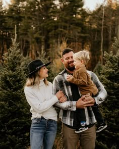 a man, woman and child are standing in front of christmas trees at the tree farm