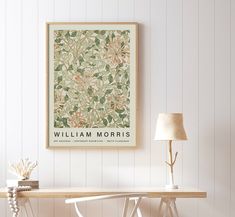 a table with a lamp and a painting on the wall above it that says william morris