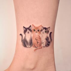 three cats tattoo on the ankle with one cat looking at the camera and another sitting down