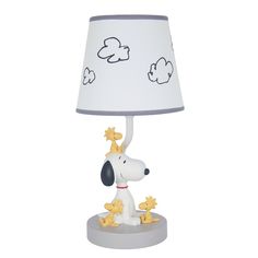 a lamp that has a dog on it with stars around the base and a white shade