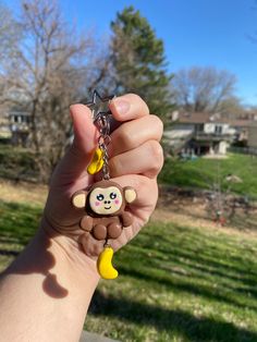 a person holding up a key chain with a monkey on it