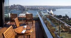 two wooden chairs sitting on top of a balcony