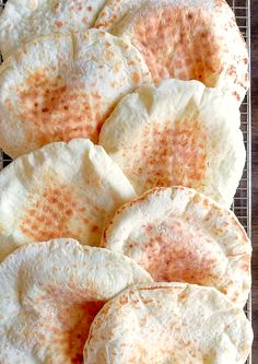 several pita breads on a cooling rack with some brown and white stuff in the middle