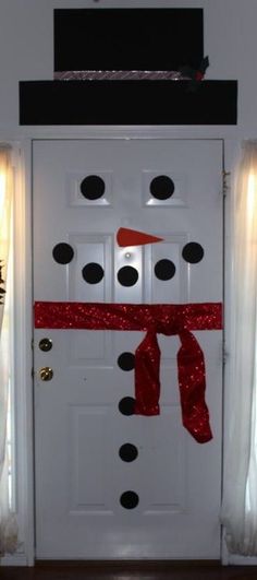 a white door decorated with a red ribbon and a snowman