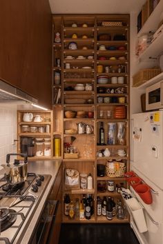 a kitchen with wooden cabinets and shelves filled with dishes on top of stove tops next to an oven