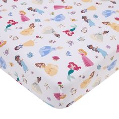 a white sheet with princesses on it and flowers all over the bottom of it