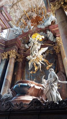 an ornately decorated building with statues on the ceiling