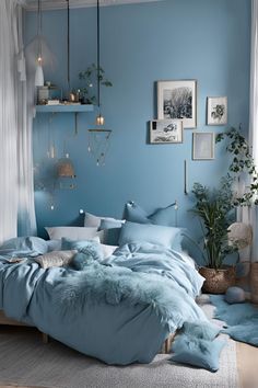 a bed with blue sheets and pillows in a room filled with pictures on the wall