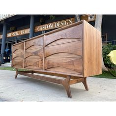 a wooden cabinet sitting on top of a sidewalk