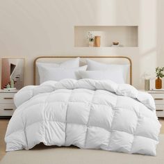 a white comforter is on the bed in a room with beige walls and flooring