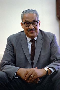 a man in a suit and tie sitting down