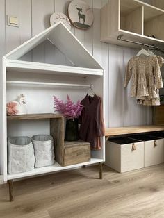 an open closet with clothes and shoes on the shelves, next to a shoe rack