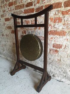 a metal plate on a wooden stand in front of a brick wall