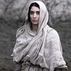 a woman wearing a shawl and holding a frisbee in her right hand