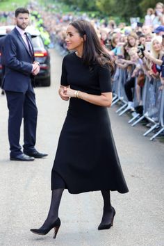 the duke and duchess of cambridge are walking in front of a crowd