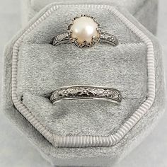 two rings sitting on top of each other in a velvet box with a white background