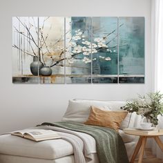 a living room with a white couch and paintings on the wall above it's coffee table