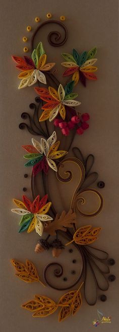 an intricately designed wall hanging with flowers and leaves