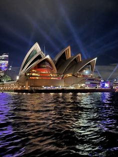 the sydney opera is lit up at night