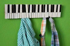 two ties are hanging on the wall next to a piano key rack with clothes hung from it