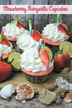 strawberry margarita cupcakes with whipped cream and strawberries on the top, surrounded by seashells