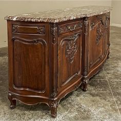 an ornate wooden cabinet with marble top