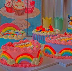 there are three cakes with rainbow frosting on them