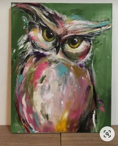 an owl painting is displayed on a wooden shelf in front of a white wall and green background